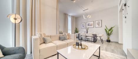 A modern living room with a sofa, coffee table, and dining area.