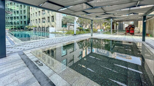 An indoor swimming pool with a clear view of the surrounding buildings and a covered seating area. - Canal View, Walking Distance to Bay Avenue Mall, Mins to Downtown Dubai (Dubai)