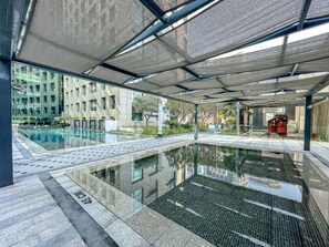Piscina interna con vista chiara sugli edifici circostanti e area relax coperta.