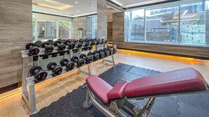 A gym with a bench, dumbbells, and a mirror. - Canal View, Walking Distance to Bay Avenue Mall, Mins to Downtown Dubai (Dubai)