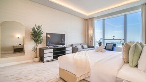 A modern hotel room with a large bed, a flat-screen TV, a potted plant, and a city view. - Heavenly Studio at The Palm Tower Palm Jumeirah by Deluxe Holiday Homes (Dubai)