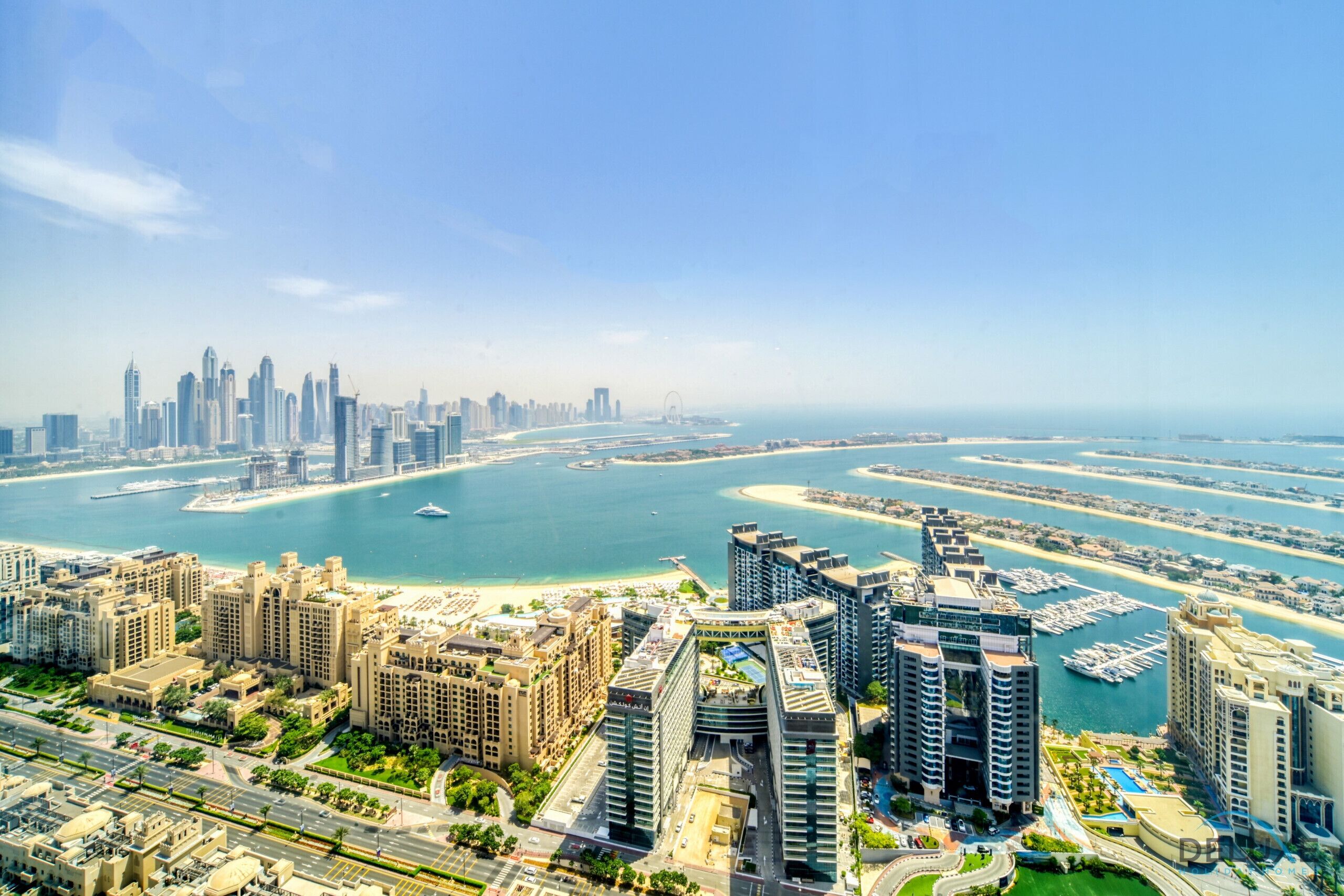 A high-rise hotel with multiple floors, a marina with boats, and a city skyline in the background.