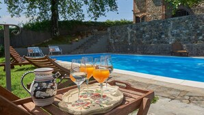 Un'area piscina con un tavolo apparecchiato per un pasto, comprensivo di una caraffa, bicchieri e un vassoio.