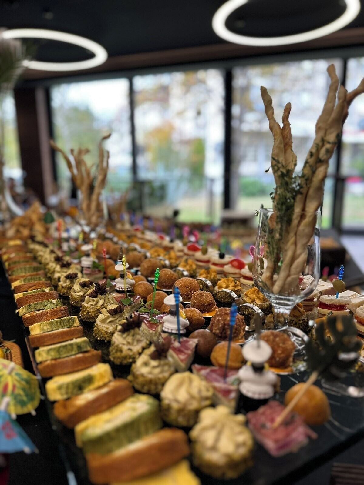 A buffet table with various food items and a decorative centerpiece.
