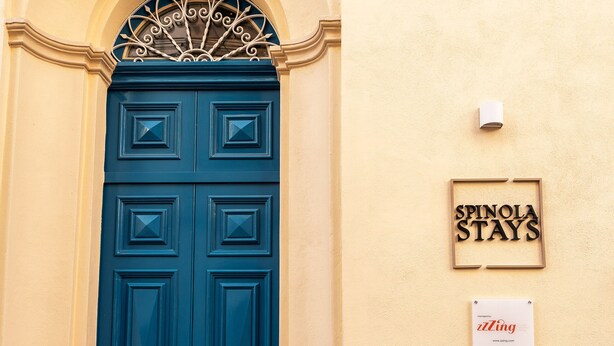 A blue door with a sign above it that reads "SPINOLA STAYS". - Spinola Stays (St. Julian's)
