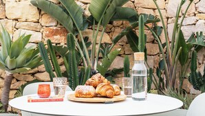 A table with croissants, a book, and a water bottle. - Spinola Stays (St. Julian's)