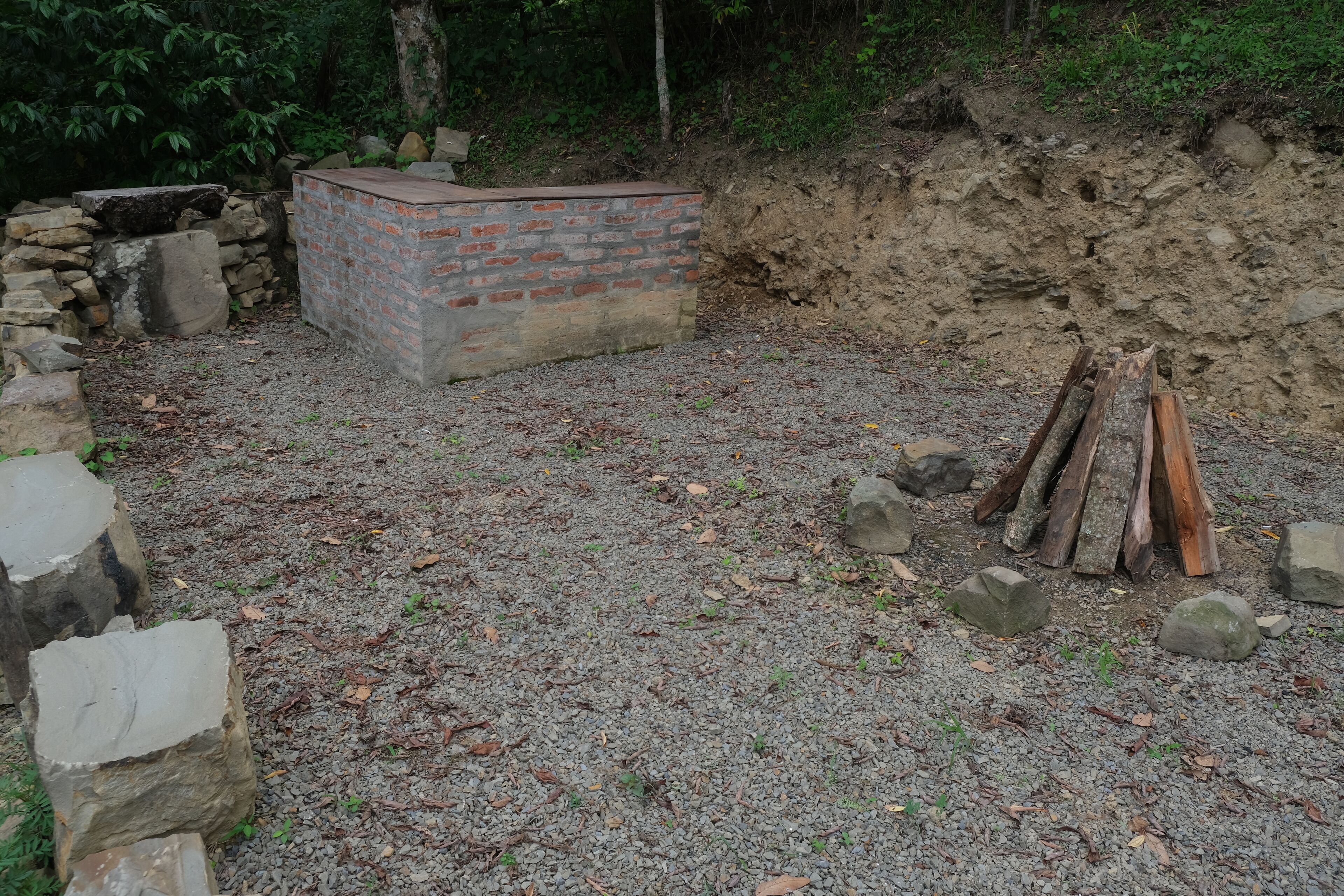 A construction site with a brick structure, gravel ground, and scattered rocks.