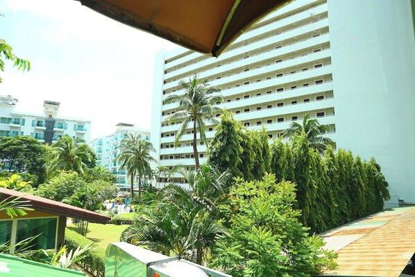 A multi-story hotel with a modern design, featuring a rooftop garden with various trees and shrubs. - Sukcheewa Residence Phuket (Patong)