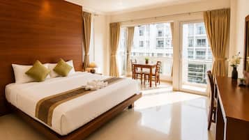 Habitación de hotel con una cama grande, una mesa de comedor y vistas a la ciudad.