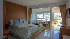 Une chambre d’hôtel avec un grand lit, un bureau, une chaise et un téléviseur.