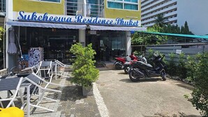 Sukcheewa Residence Phuket, avec espace extérieur aménagé et motos garées.