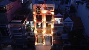 A multi-story building with a prominent sign for PVT Hotel. The building features balconies and a central staircase. - PYNT Hotel (Ho Chi Minh City)