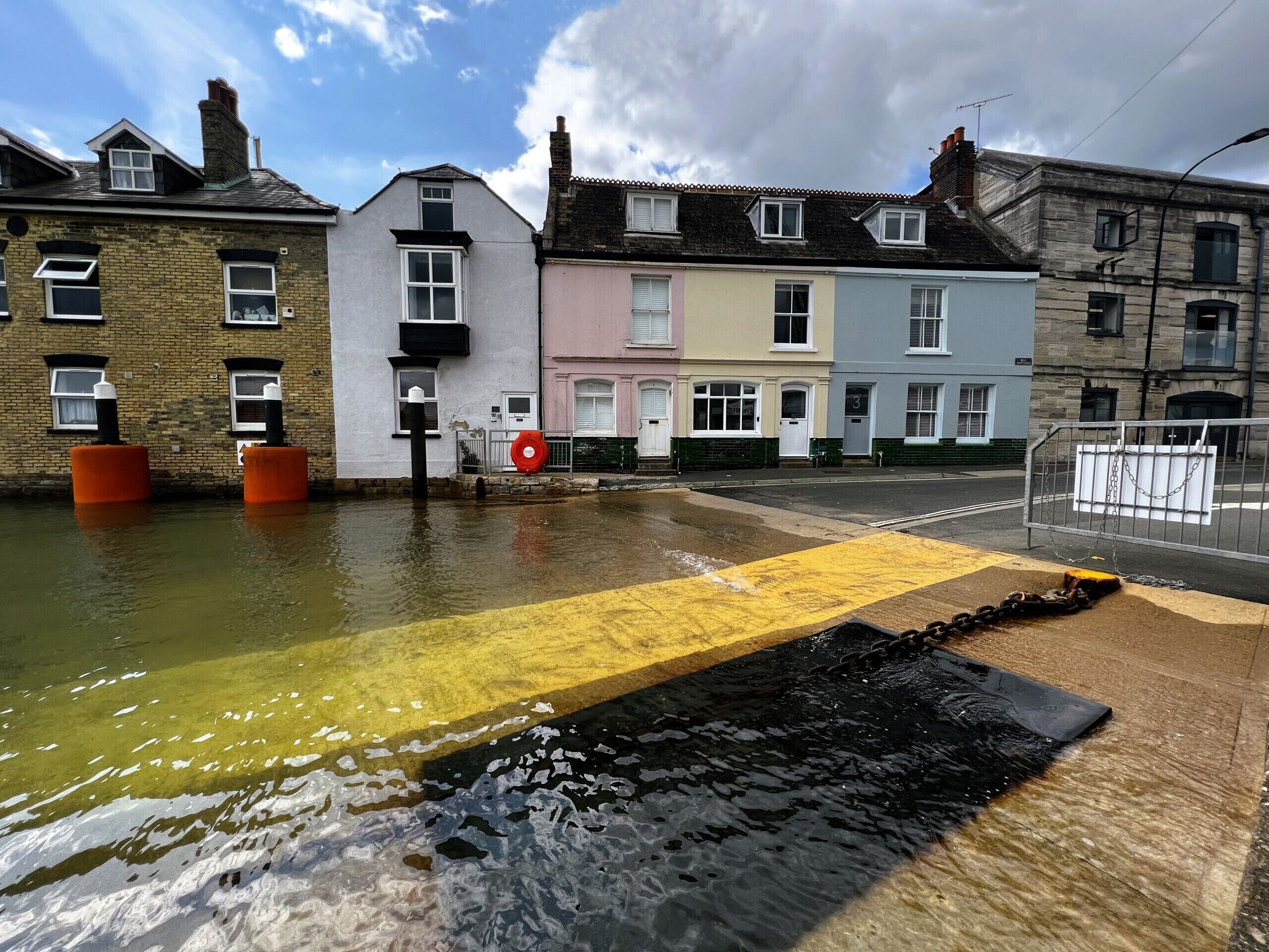 Une rue inondée, l’eau recouvrant la chaussée et le trottoir.