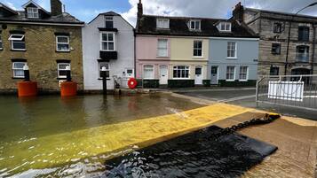 Une rue inondée, l’eau recouvrant la chaussée et le trottoir.