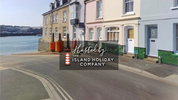 A row of terraced houses by a waterfront, with a clear view of the sea. - Bell Cottage (Cowes)