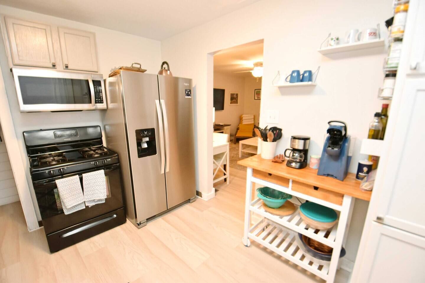 A compact kitchen with a stove, microwave, and refrigerator.