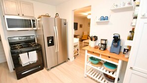 Cocina compacta con estufa, microondas y refrigerador.