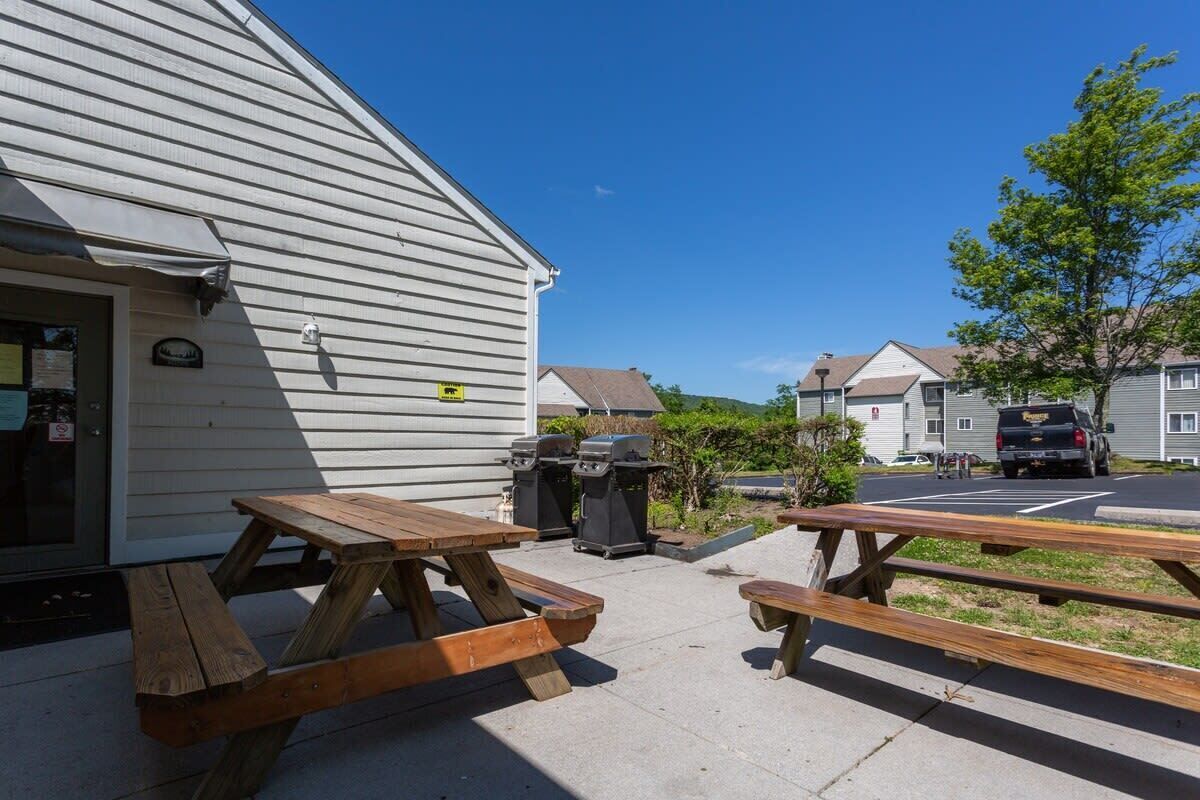 A building with a covered patio area featuring picnic tables.