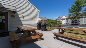 En bygning med en overdækket terrasse og picnicborde.