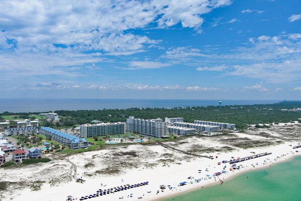Un resort con varias edificaciones, una playa y un muelle.