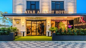 The exterior of the Atar Airport Hotel with a checkered pavement, a glass entrance, and a floral wall decoration. - Atar Airport Hotel - Restaurant & Spa Wellness (Arnavutköy)
