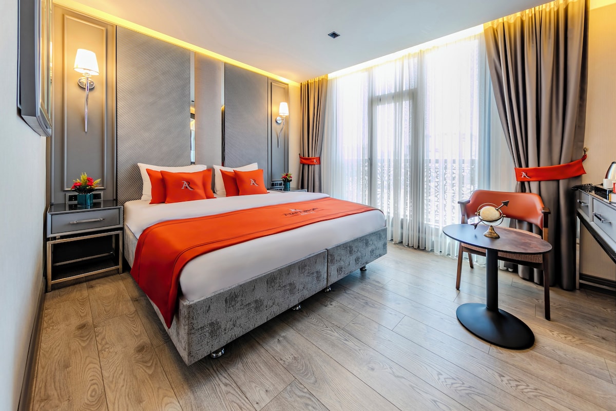 Una habitación de hotel moderna con una cama grande, un escritorio y una silla.