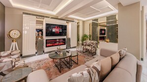 A modern living room with a fireplace, a large flat-screen TV, and comfortable seating. - Atar Airport Hotel - Restaurant & Spa Wellness (Arnavutköy)