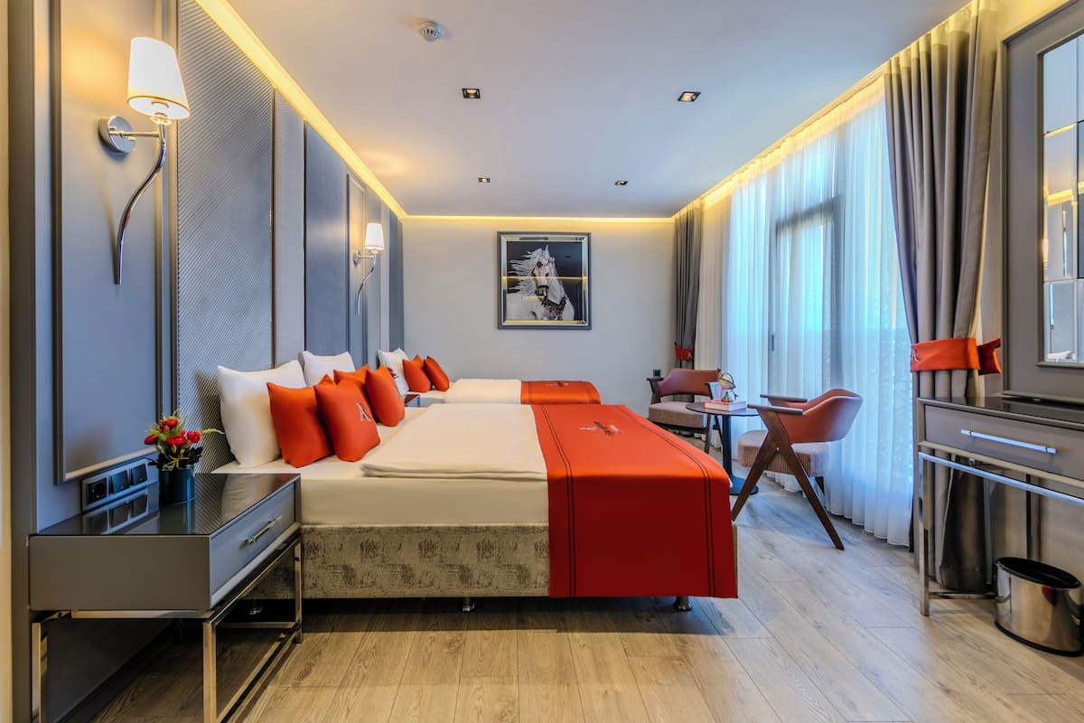 Una habitación de hotel moderna con una cama grande, un escritorio, una silla y un área de comedor.