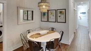 Un coin repas comprenant une table ronde, six chaises et un lustre.