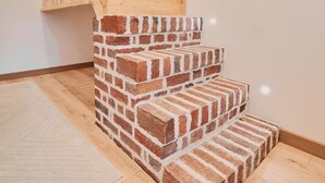 A staircase with wooden steps and a brick wall.