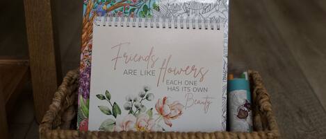 Ein Korbkobild mit einem Notizbuch mit floralen Mustern und einer Karte mit einem Zitat.