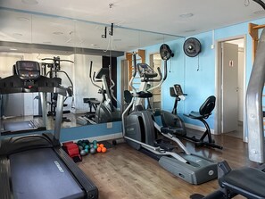 A gym with cardio machines, weights, and a mirror. - Flat Moema 203 (São Paulo)