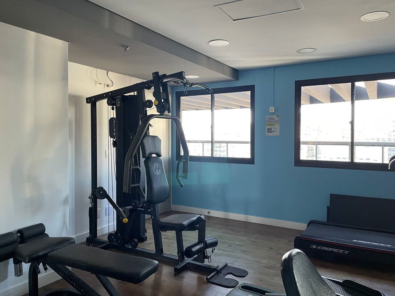 A gym with exercise equipment, a bench, and a treadmill.
