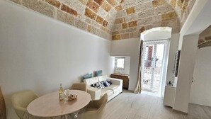 Un salón espacioso con una mesa redonda, un sofá y una ventana.