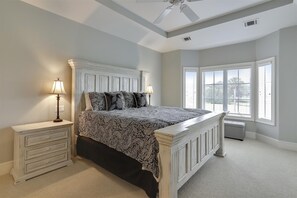 A bedroom with a bed, nightstands, a window with blinds, and a ceiling fan. - Sunset Rentals | Lookout 3 | Dog Friendly (Hilton Head Island)