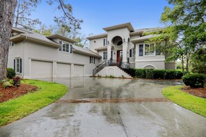 A two-story house with a central entrance, a driveway, and a well-maintained lawn. - Sunset Rentals | Lookout 3 | Dog Friendly (Hilton Head Island)