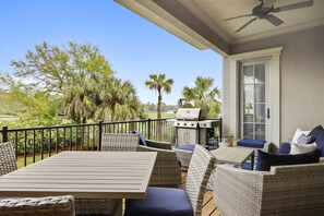 Enjoy al fresco dining and cooking in this outdoor space with a grill and wicker furniture.