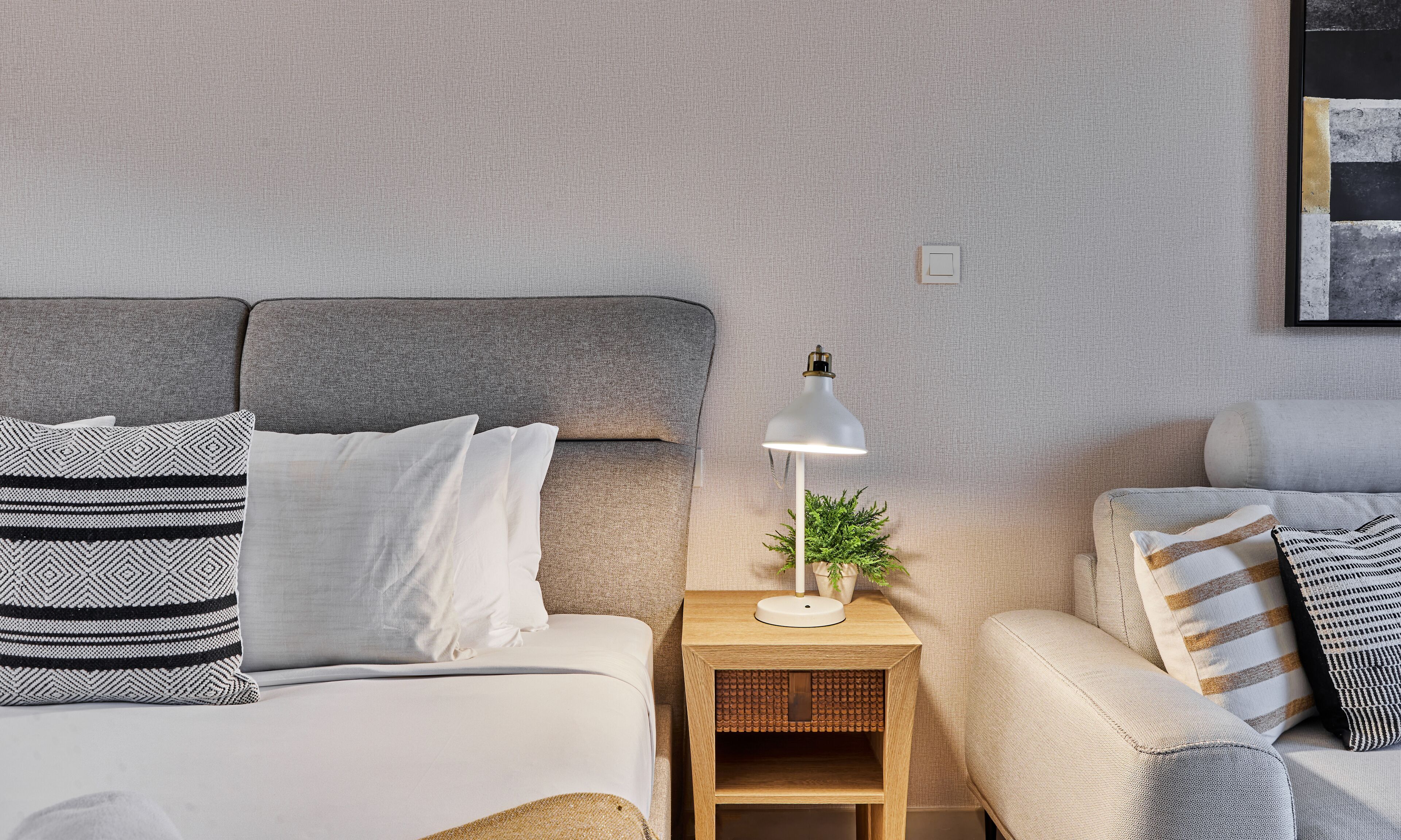 A neatly arranged bedroom with a bed, bedside tables, and a lamp.
