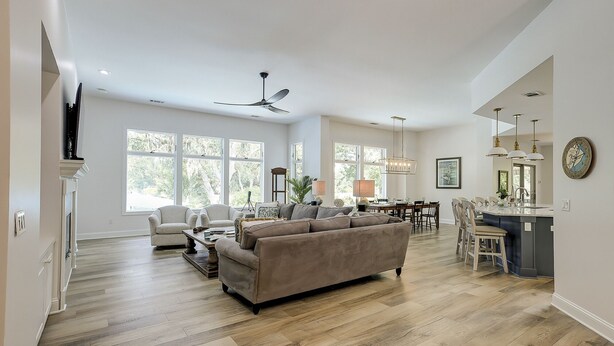 A spacious living room with a large sofa, a dining area, and a kitchen with a bar. - Sunset Rentals | Kingston 47 (Hilton Head Island)