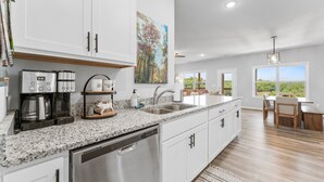 A modern kitchen with granite countertops, stainless steel appliances, and white cabinetry. - Tee House At Stonebridge 3 Bedroom Condo by RedAwning (Branson West)