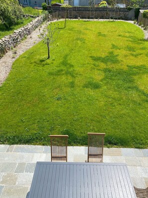 A patio with two wooden chairs and a stone wall in the background. - Beautiful Architect-Designed House, Kérity (Penmarc'h)