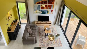 Ein modernes Wohnzimmer mit einer Couch, einem Fernseher und Kunstwerken an der Wand.