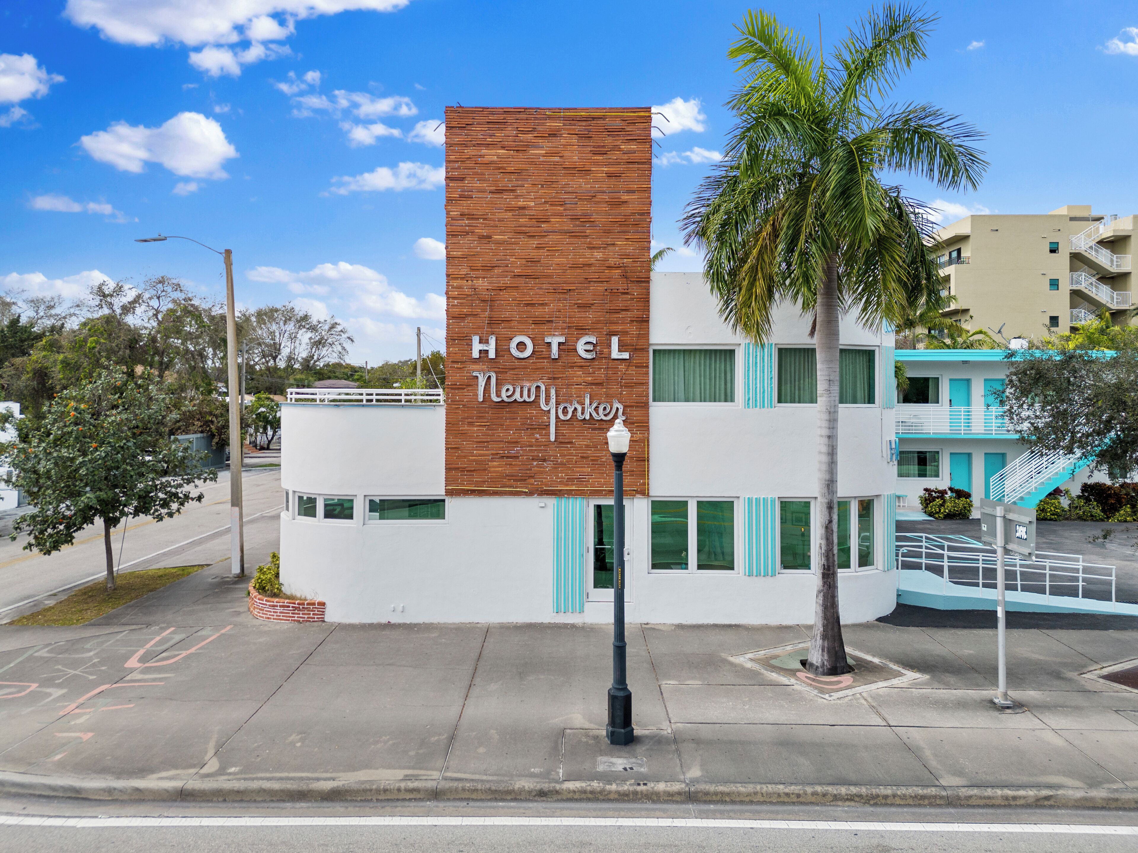 Un hôtel moderne avec une façade en briques imposante et une enseigne indiquant « HÔTEL New Yorker ».