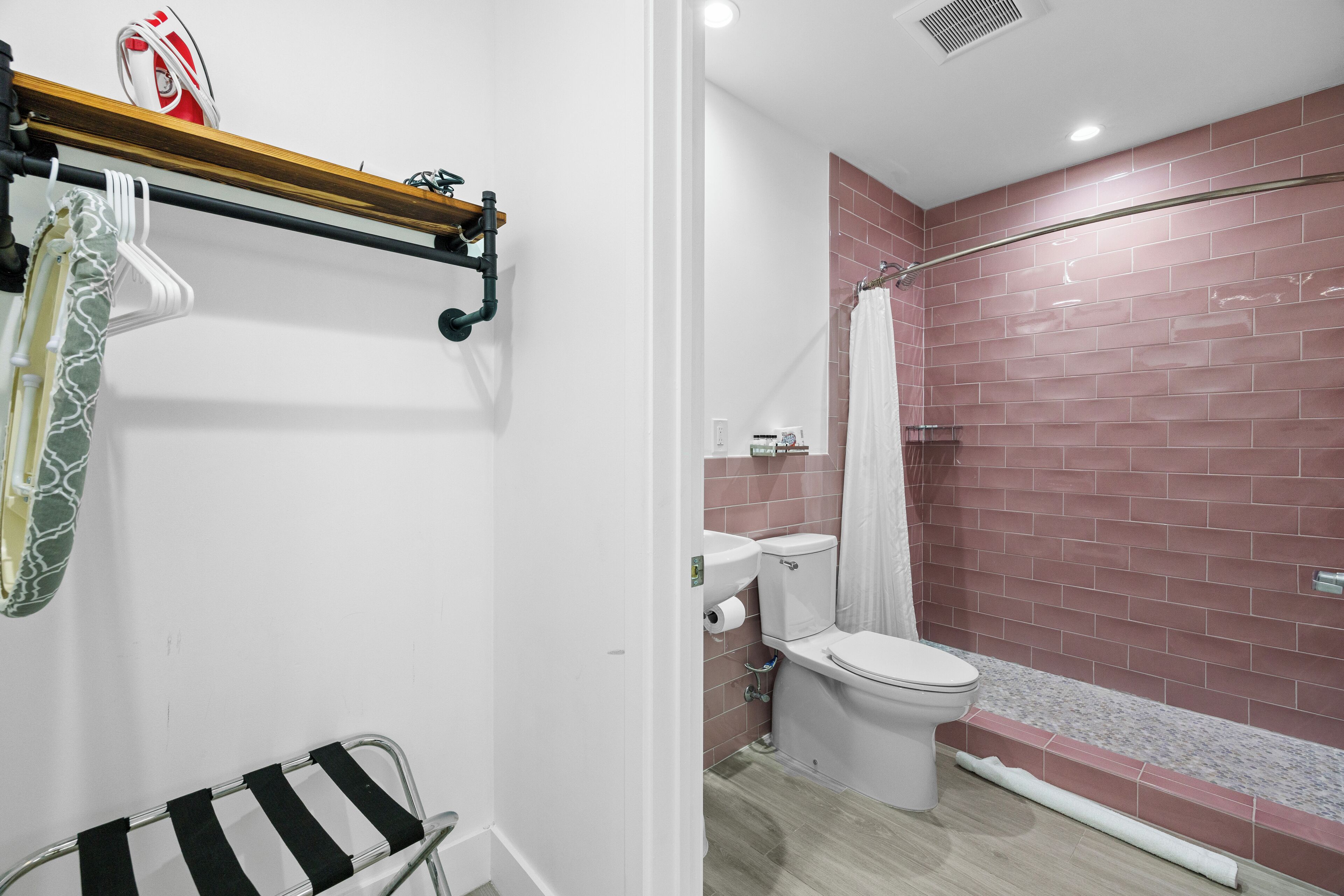 A bathroom with a shower, toilet, and a towel rack.