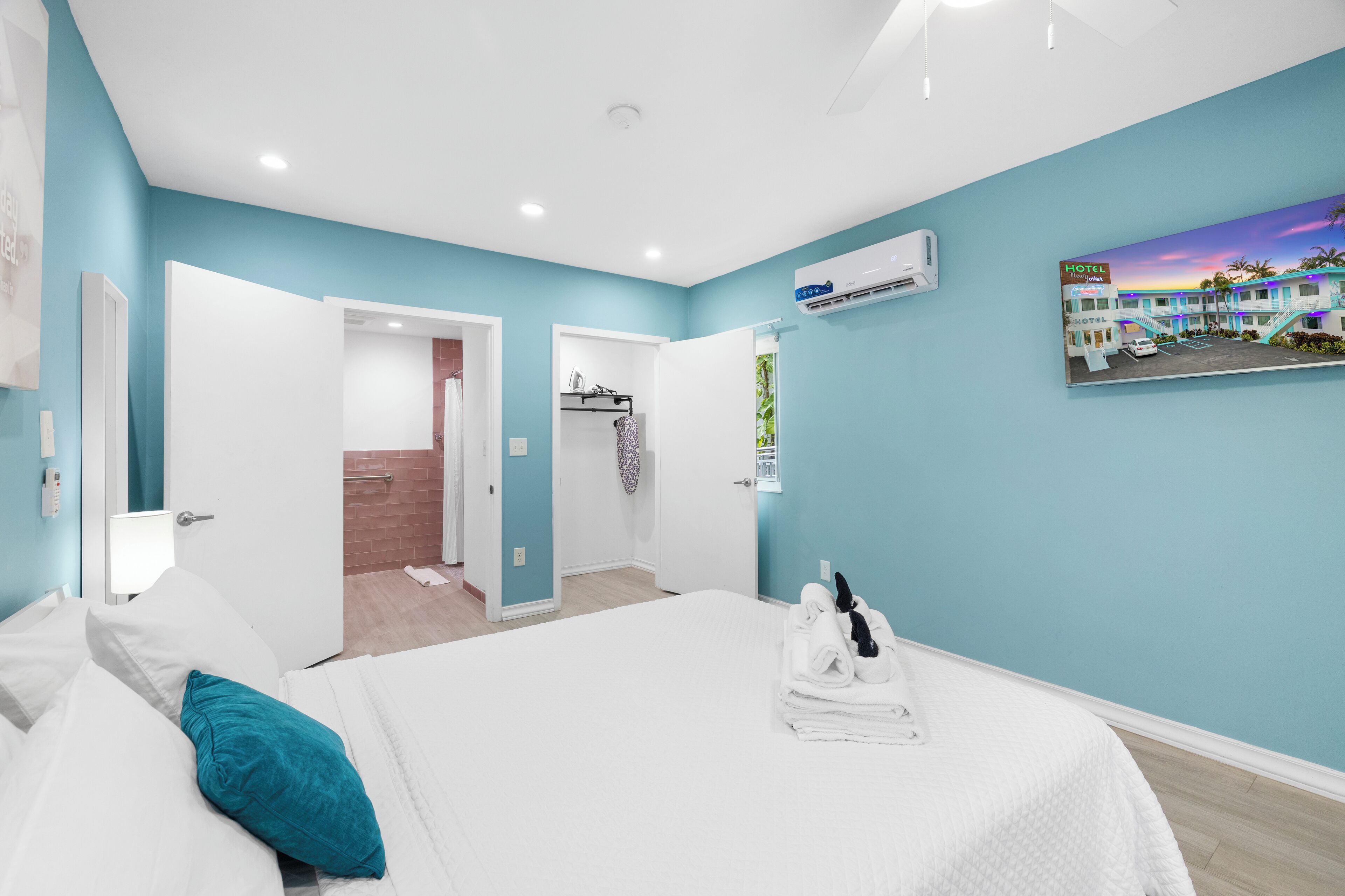 Een moderne hotelkamer met een groot bed, een badkamer met douche en uitzicht op een ander hotelgebouw.