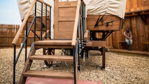 A covered wooden structure with a door and a set of wooden steps leading up to it. - The Big Texan - Cabins & Wagons  (Amarillo)