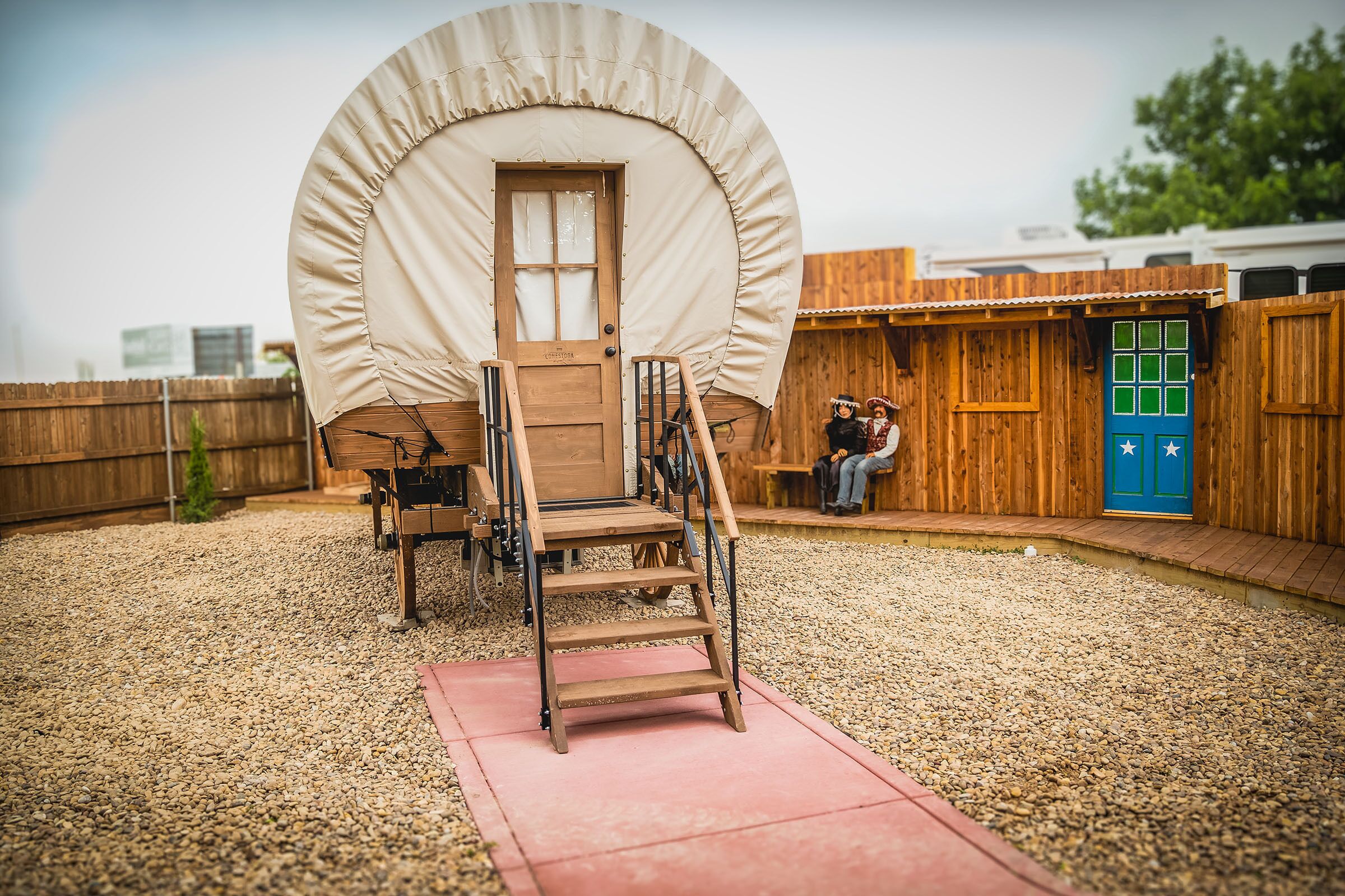 Modelo de uma cabana rústica com porta de madeira, um lance de escadas e uma pequena varanda.