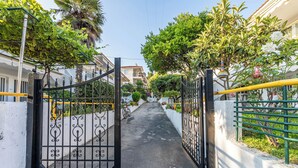 A gated pathway leading to a residential area with a bicycle parked by the gate. - Nano's Vacation In Nea Skioni  (Kassandra)