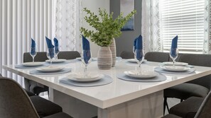 Enjoy meals in this stylish dining area with a long table, potted plant, and beautiful views.