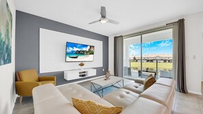 Relax in this stylish living room with a flat-screen TV, comfortable sofa, and a coffee table.